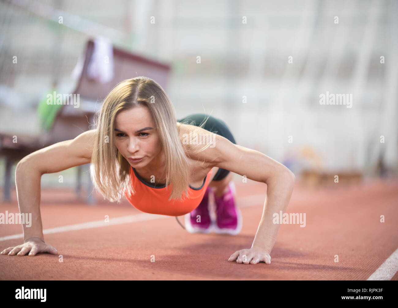Colocar joven mujer atlética hacer empuje ups Foto de stock