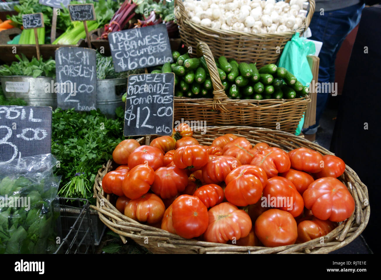 Los tomates frescos, libanés pepinos y otras verduras que se vende en el mercado de la reina Victoria Melbourne, Victoria, Australia Foto de stock