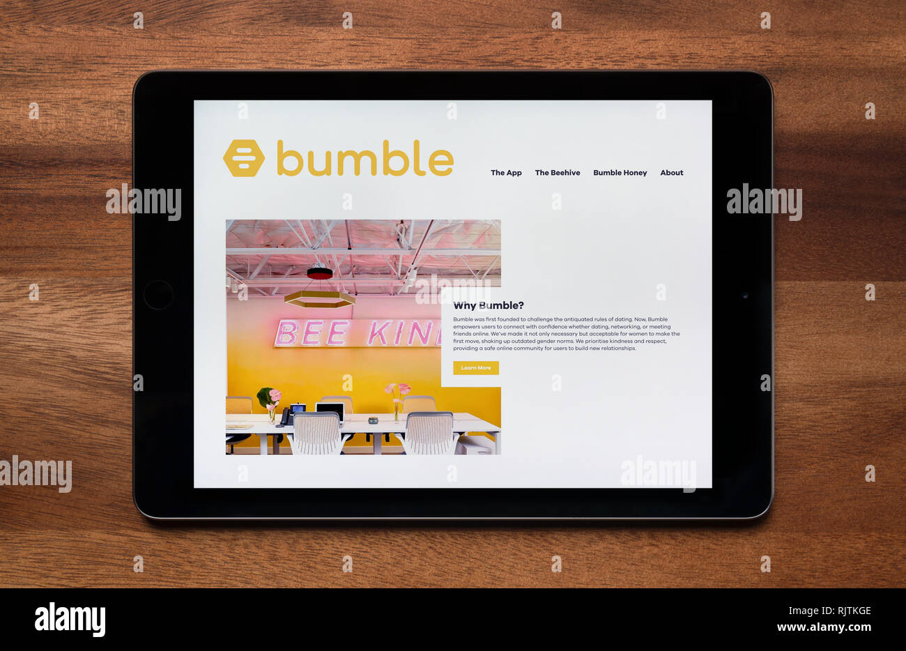 El sitio web de Bumble dating app es visto en un iPad, que descansa sobre una mesa de madera (uso Editorial solamente). Foto de stock