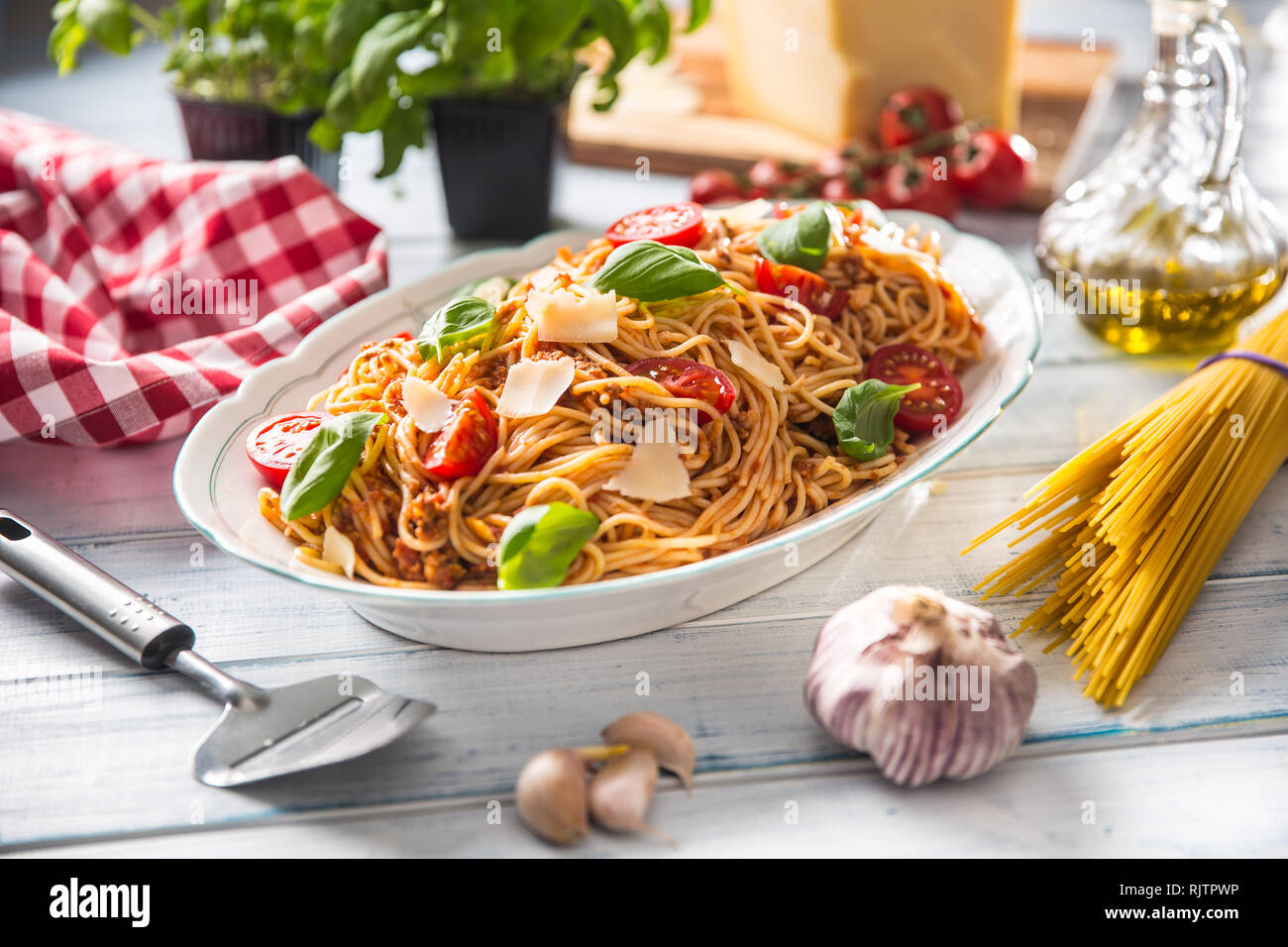 Las pastas italianas los espaguetis a la boloñesa en blanco tazón con tomates y albahaca queso parmesano. Foto de stock