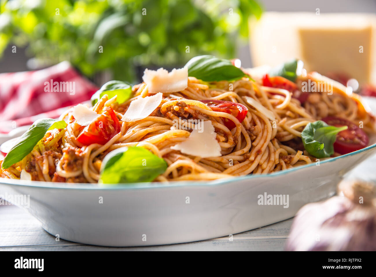 Las pastas italianas los espaguetis a la boloñesa en blanco tazón con tomates y albahaca queso parmesano. Foto de stock
