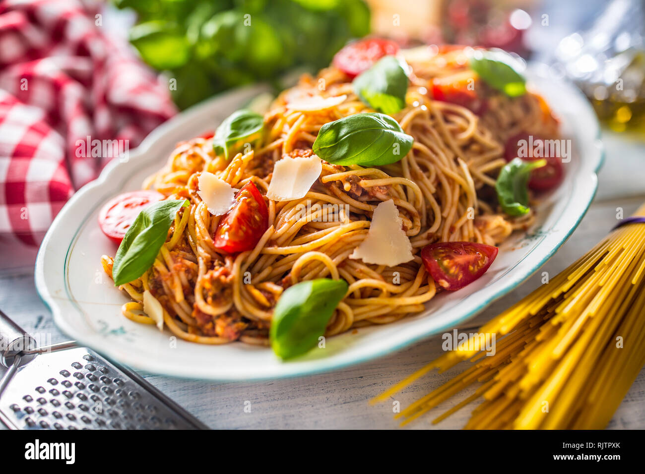 Las pastas italianas los espaguetis a la boloñesa en blanco tazón con tomates y albahaca queso parmesano. Foto de stock