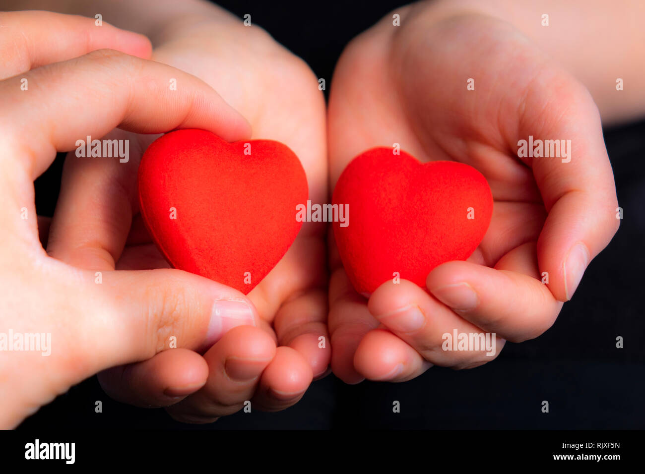 Corazones rojos dibujo en manos de una pareja tomados de la mano, amantes,  símbolo de amor, de convivencia, de manos sosteniendo, el amor, el Día de  San Valentín Fotografía de stock -