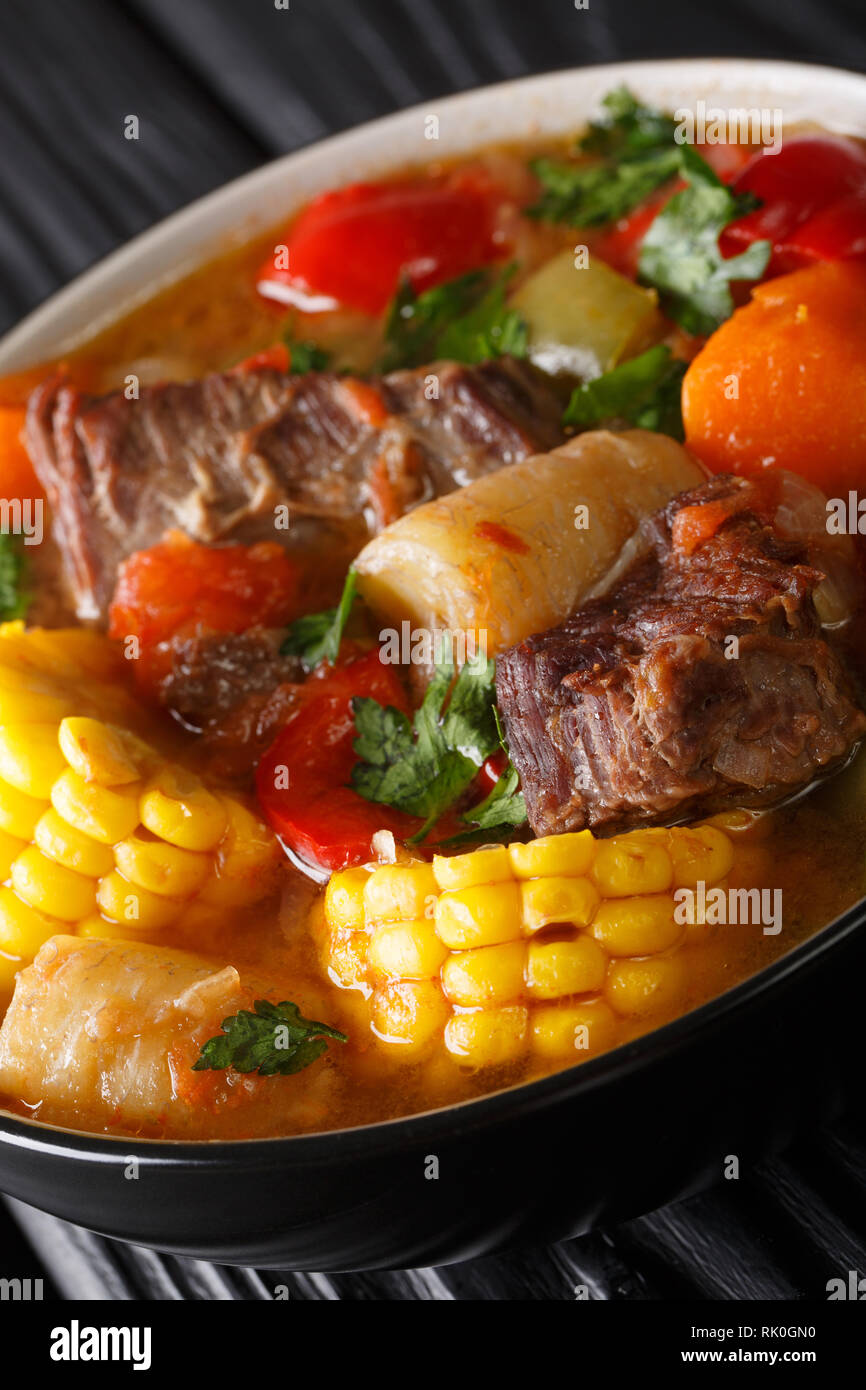 Una receta de Sancocho de un abundante y delicioso guiso hecho con carne, verduras y especias de cerca en un plato sobre la mesa. Vertical Foto de stock