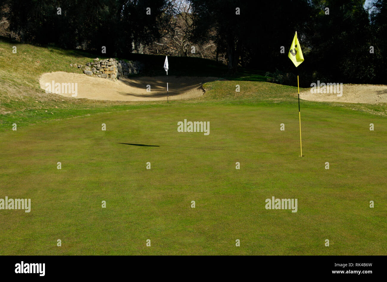 Campo de golf con palo de bandera en un día soleado Foto de stock