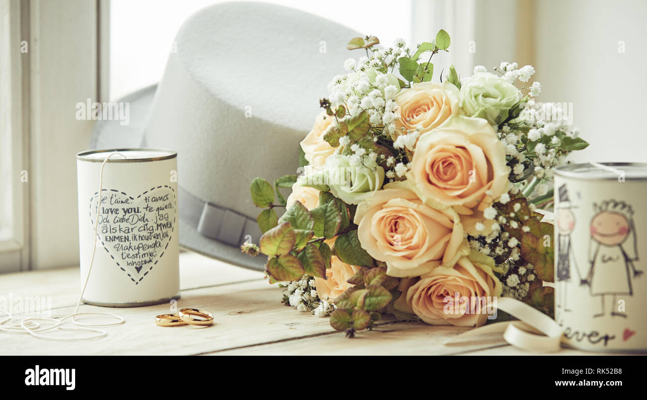 Decoración de matrimonio composición con escobas sombrero blanco, anillos de  boda, un ramo de rosas rosas y un par de latas decoradas con deseos,  sentado en formul Fotografía de stock - Alamy