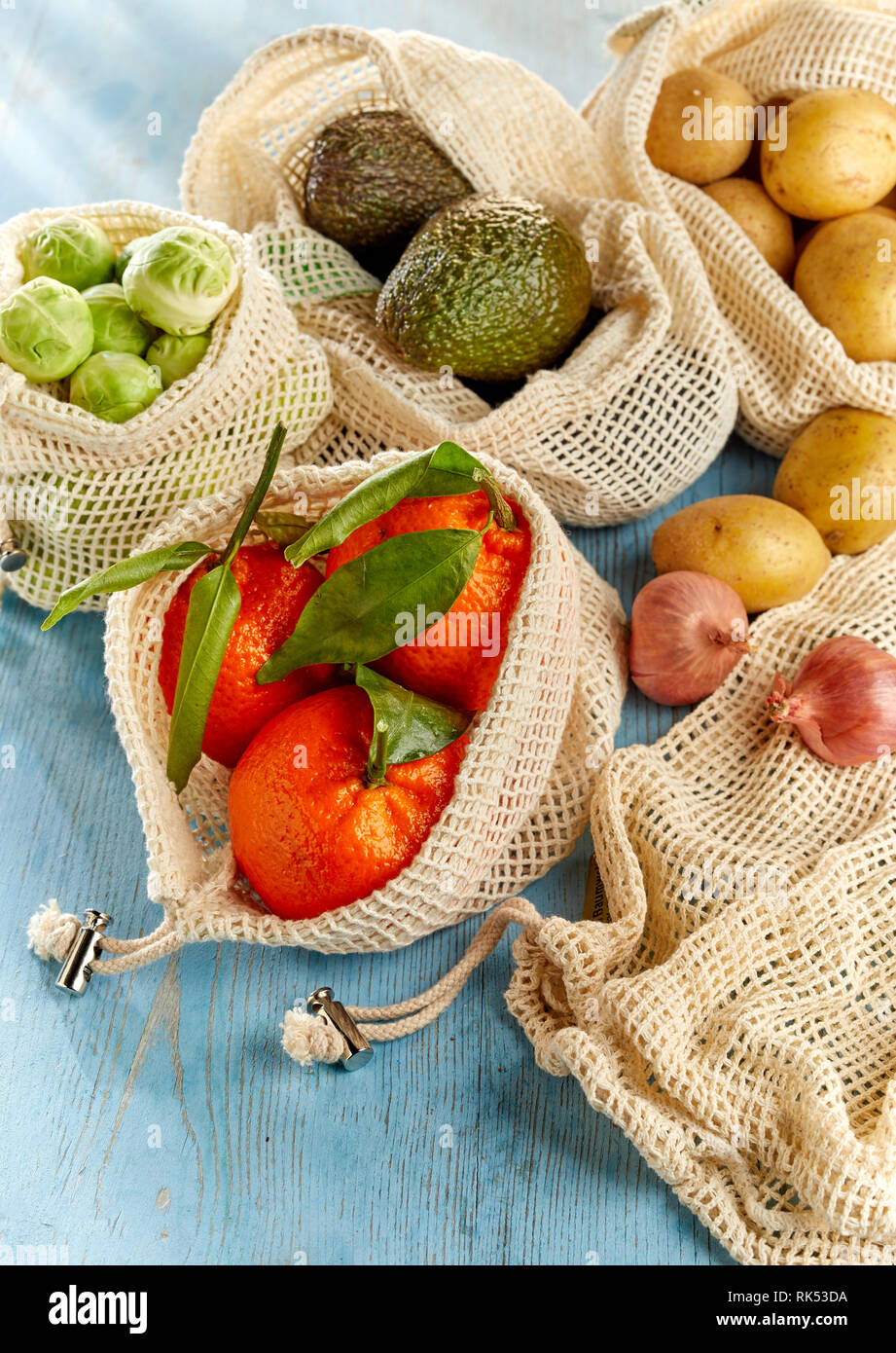 Net bolsas con comestibles orgánicos surtido de frutas y verduras, vistos desde arriba en primer plano. Comida sana y respetuosa con el medio ambiente concepto de embalaje Foto de stock