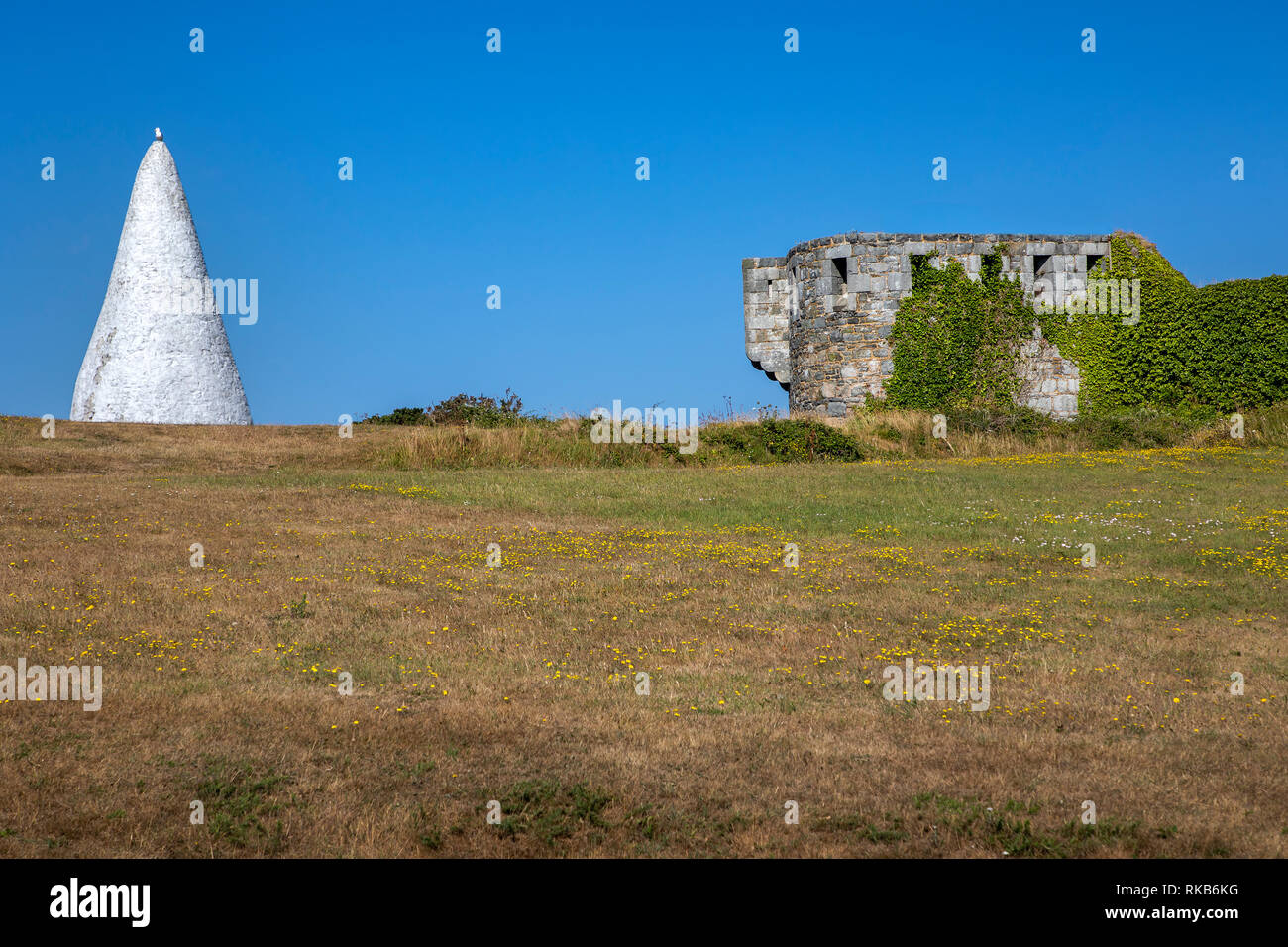 Fort Tourgis en Alderney, además de un gran hito cono blanco utilizados para el envío de la navegación. Foto de stock
