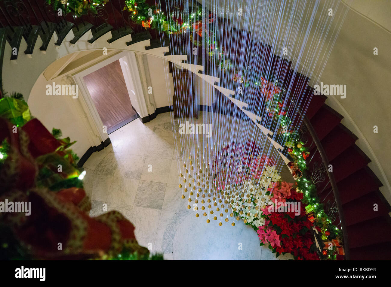 Escalera de caracol decorada para la Navidad con su iluminación única. Foto de stock