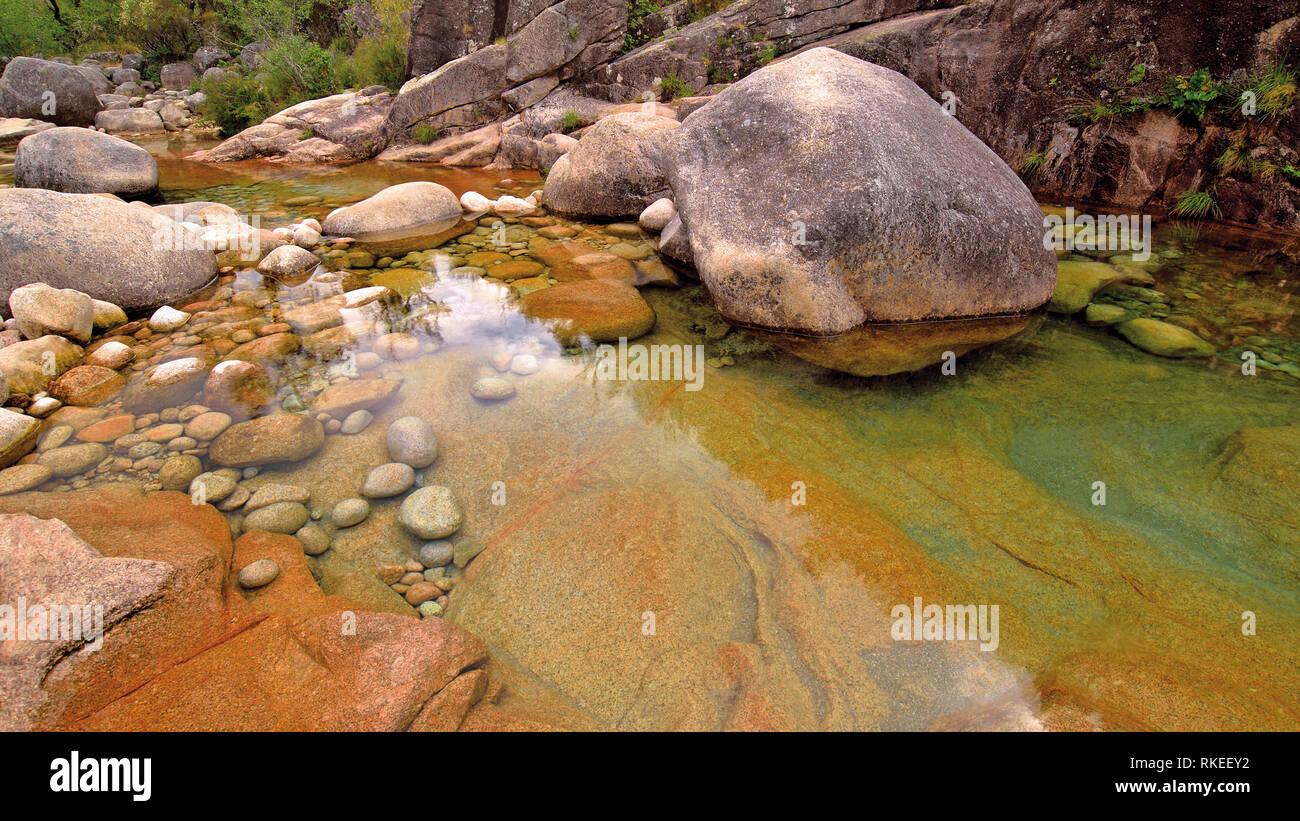 Las rocas enormes en la quebrada agreste con aguas transparentes Foto de stock