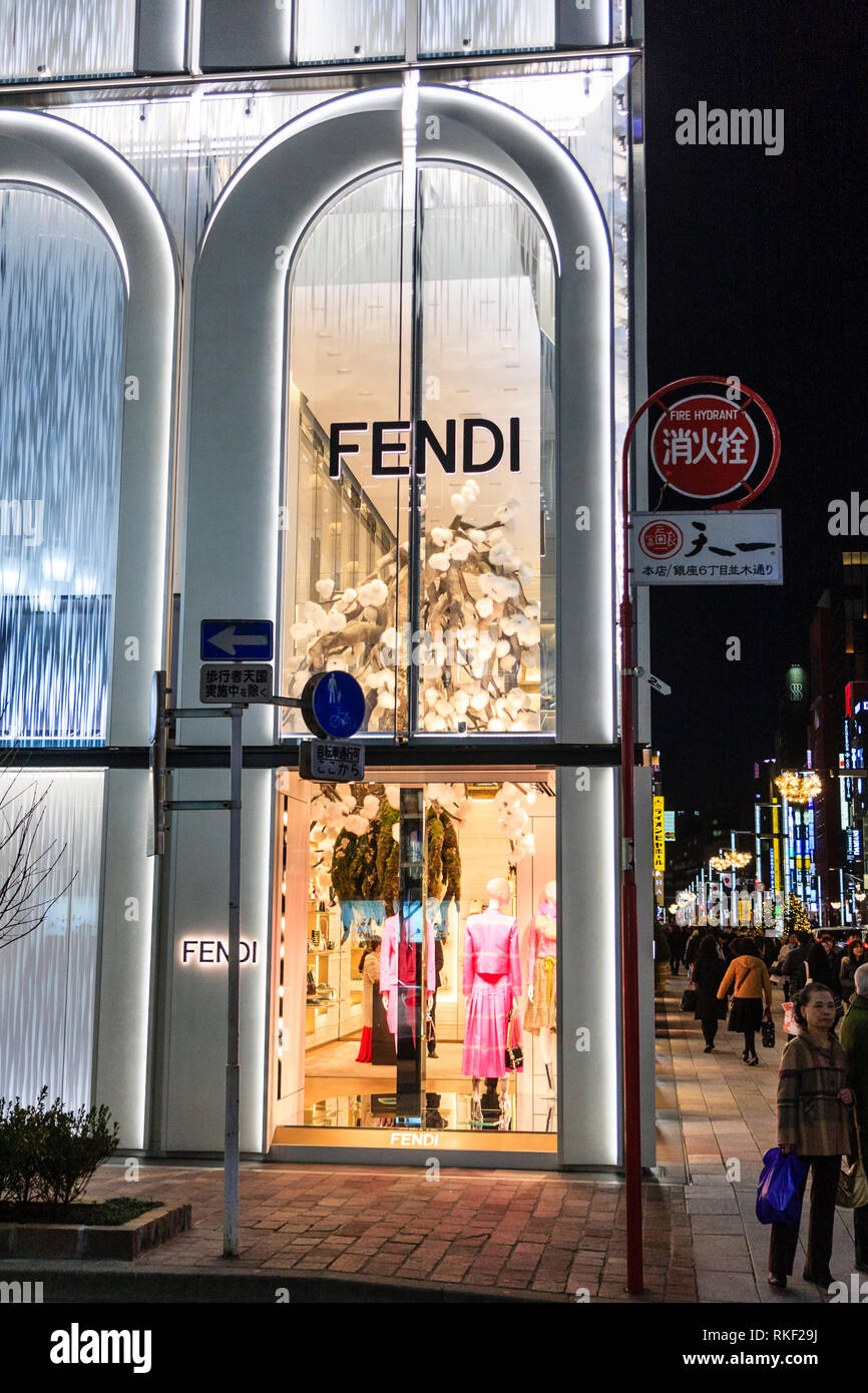 Tokyo, Ginza, noche. Mostrar ventana en la esquina de la tienda de moda mujer italiana, Fendi, y vistas de la calle y las luces. Hidrante situado junto a la ventana. Foto de stock