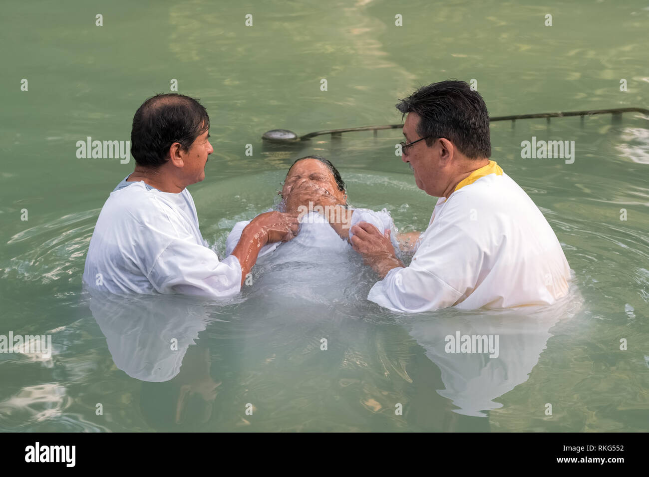 Yardenit, Israel - 29 de diciembre de 2012: la mujer no identificada peregrino cristiano obtiene bautizado en el río Jordán en el norte de Israel (sitio bautismal Yardenit). Foto de stock