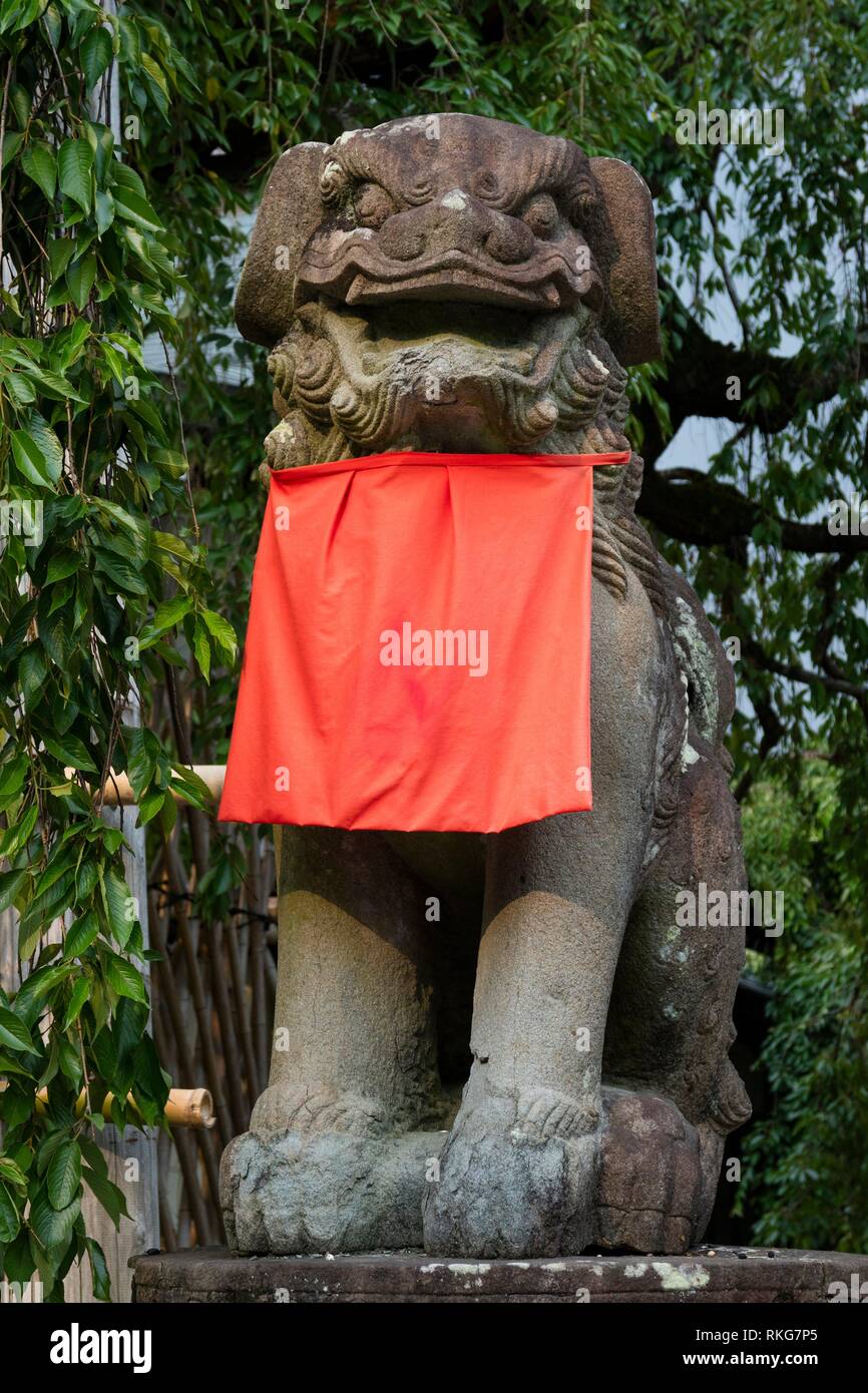 León, perro guardián de piedra Komainu, con una falda roja en el parque Nara. Foto de stock