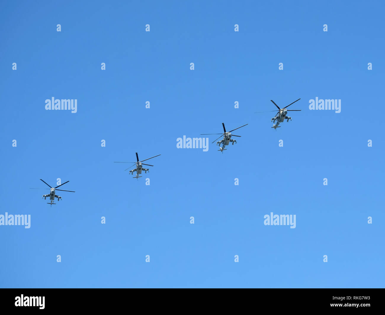 Grupo de cuatro helicópteros militares rusos MI-24P (Hind) en el azul claro del cielo en vuelo el 9 de mayo de 2018, en Moscú. Contenido editorial Foto de stock