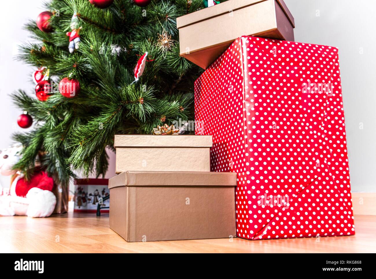 Cajas de regalo en el suelo sobre un árbol de Navidad de fondo. Buen año nuevo espíritu. Foto de stock