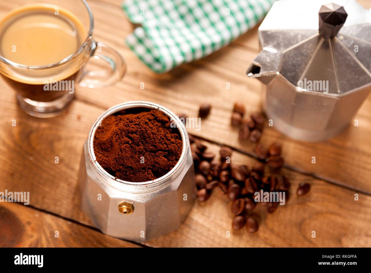 Cafetera italiana, servilleta, taza de café y granos de café en la mesa de  madera Fotografía de stock - Alamy