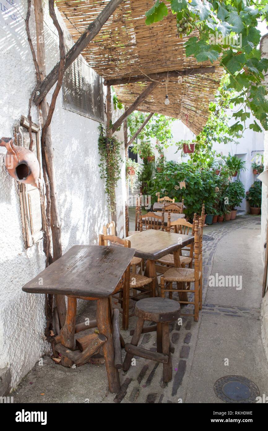 Callejuela tranquila con terraza restaurante en el pueblo de Capileira. Alpujarras, Granada, España. Foto de stock