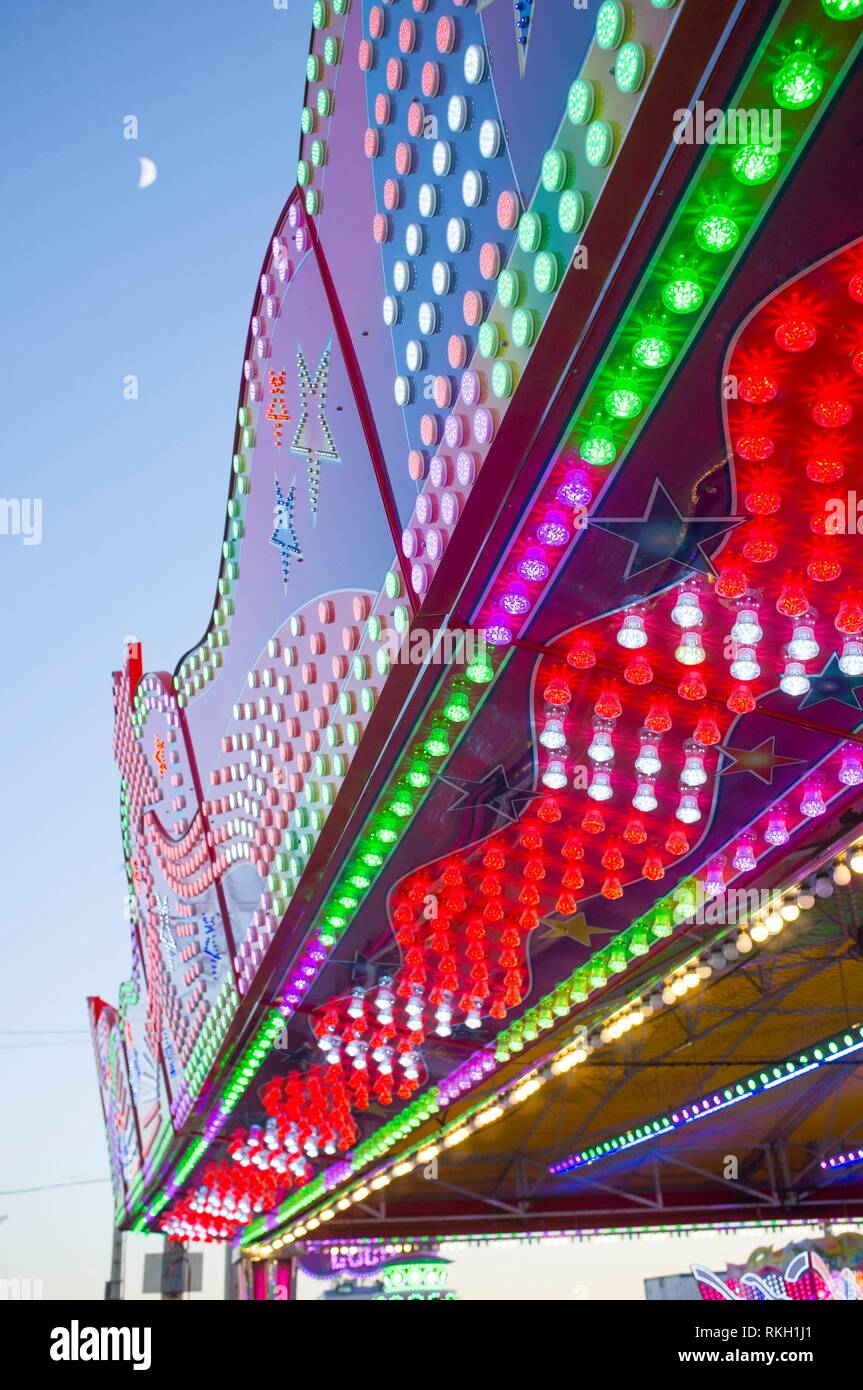 Atracción de feria delante un montón de lámparas, leds, y globos de colores. Captura de luz diurna. Foto de stock