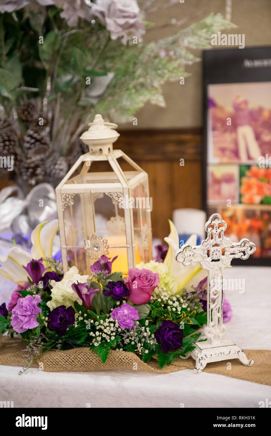 La recepción de la boda centros de mesa de velas linternas en mesas  decoradas con flores de una florería local con una cruz para honrar a  aquellos que han aprobado Fotografía de