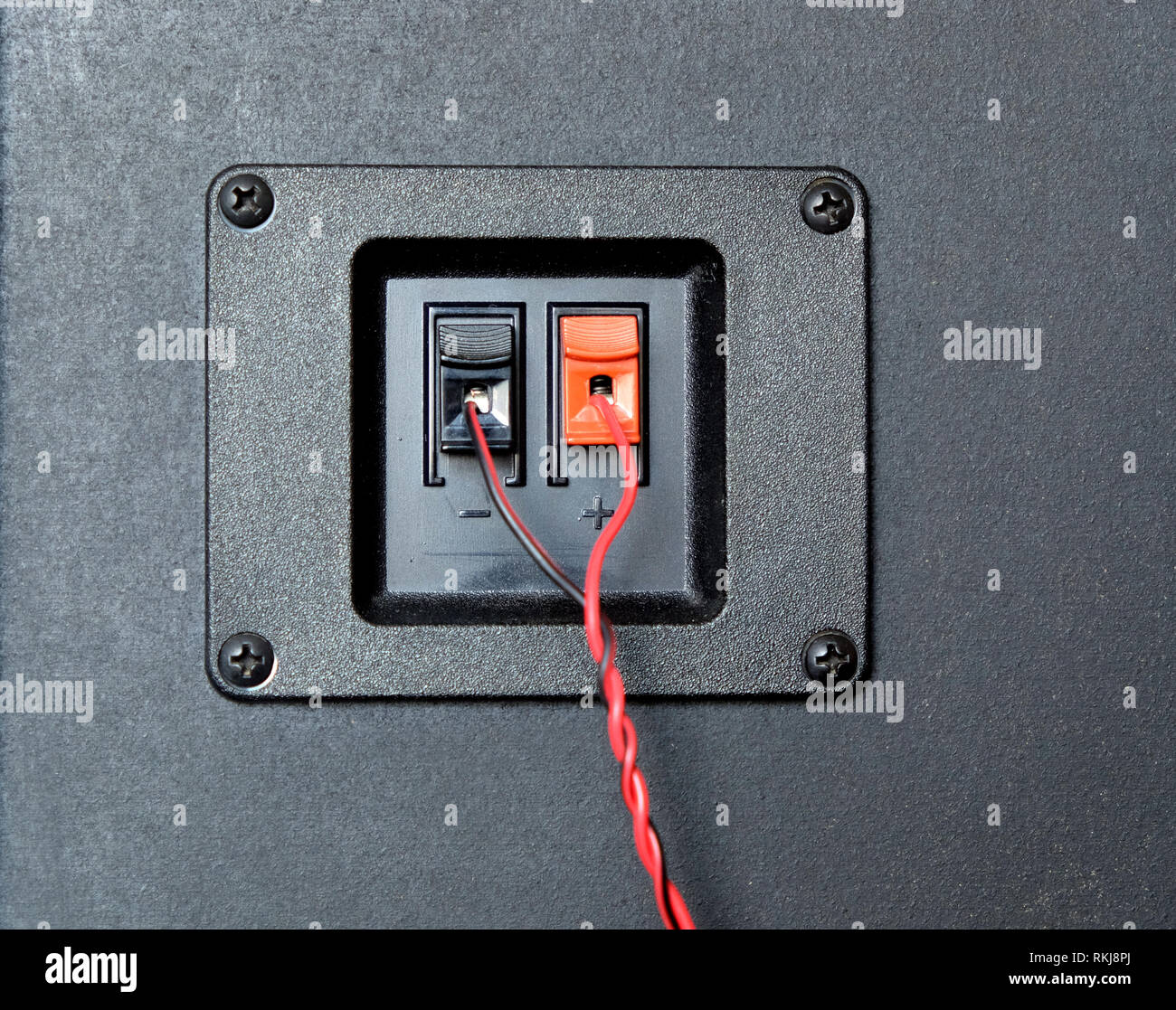Cable trenzado rojo y negro conectado a la toma de conexión de cable en la  parte trasera de los altavoces laterales de la parte delantera de la caja  del sistema ver closeup