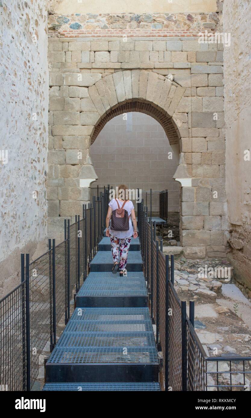 Visitante shoehorse caminando hacia el arco de la Alcazaba de Badajoz, una antigua ciudadela morisca, Extremadura, España. Puerta Alpendiz. Foto de stock