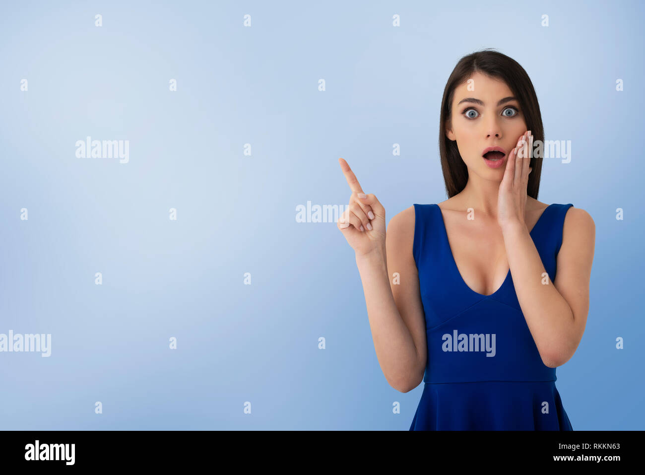 Sorprendido chica indica un espacio en blanco para su texto Foto de stock