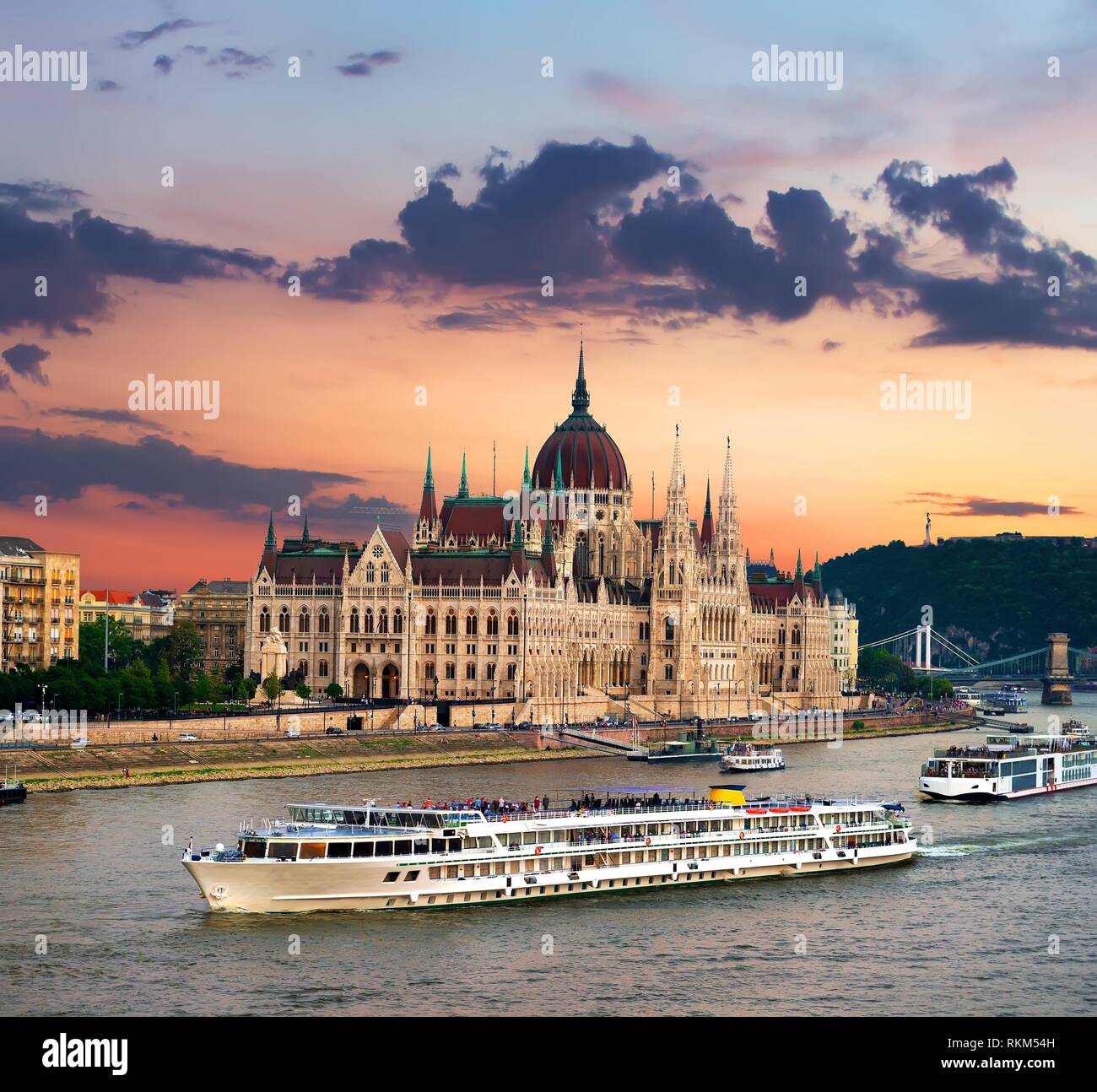 Los barcos turísticos y el Parlamento húngaro al atardecer, Budapest. Foto de stock