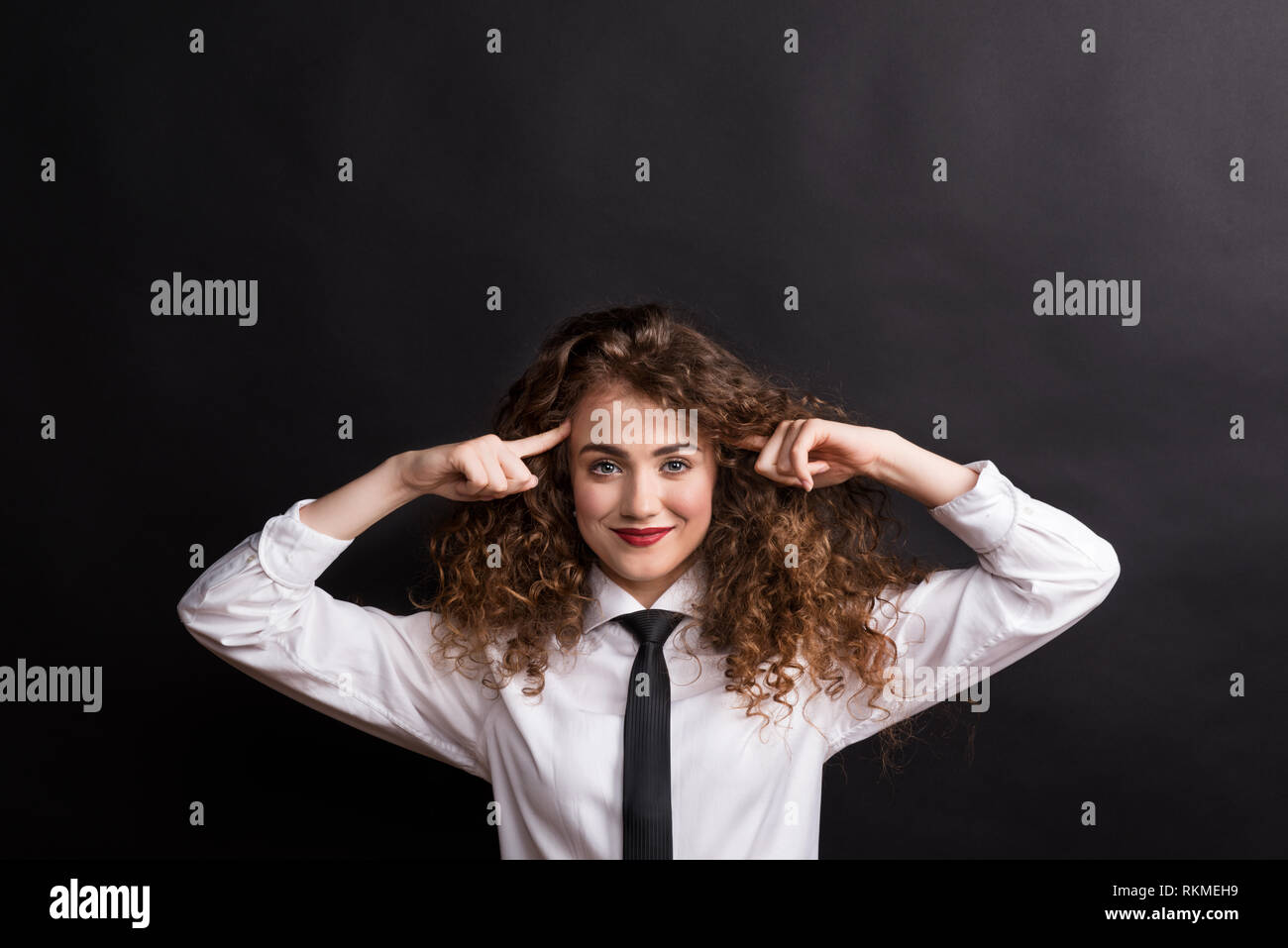 Hermosa joven mujer feliz en studio, vestido con camisa blanca y corbata  negra Fotografía de stock - Alamy