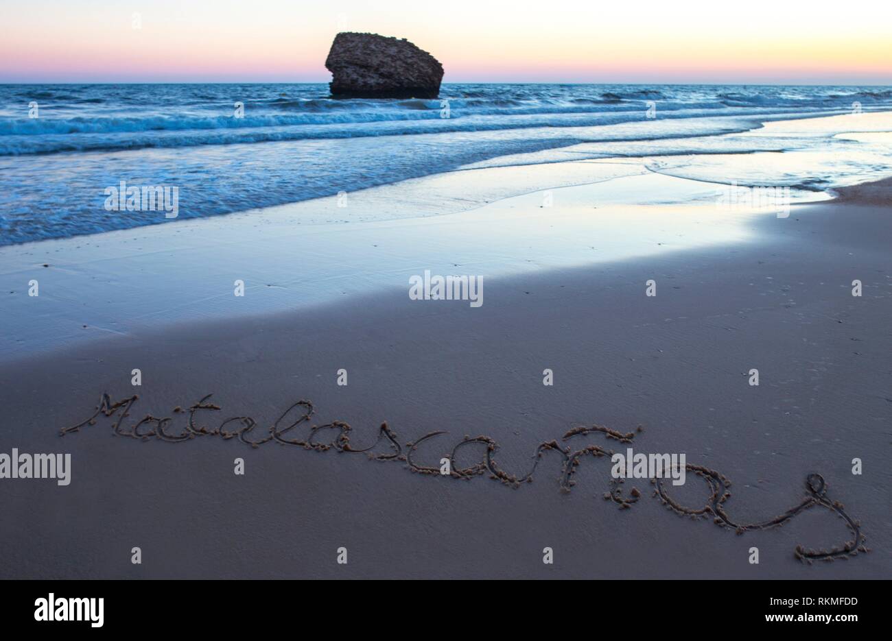 Playa Matalacanas durante la magnífica puesta de sol. A lo largo de la arena está escrito el nombre. Huelva, España. Foto de stock