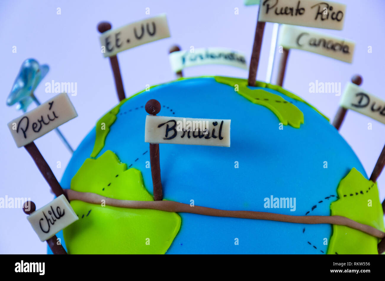 El mundo en miniatura con banderines de diferentes países y la avioneta, concepto de viaje. Foto de stock