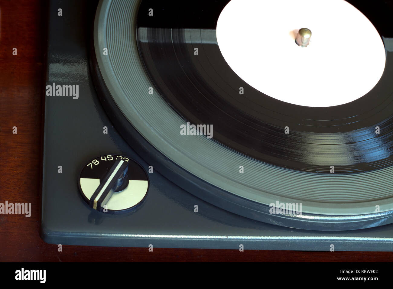 Parte del antiguo registro de tres velocidades vintage jugador jugando con discos de vinilo etiqueta blanca. Vista superior horizontal closeup Foto de stock
