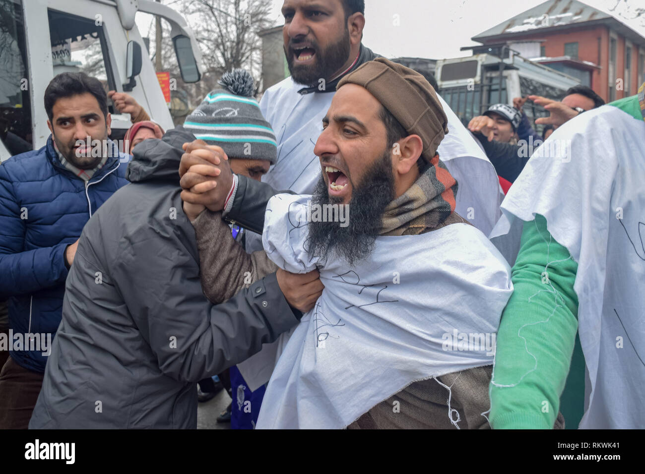 Febrero 12, 2019 - Srinagar, Jammu & Kashmir - Un miembro de la policía de Jammu y Cachemira en civvies visto detener a un miembro de NHM empleados durante la protesta en Srinagar.NHM (Misión Nacional de Salud) empleados sobre sacó una marcha de protesta contra el gobierno hacia el Raj Bhavan en Srinagar. Los empleados que han estado en huelga desde el pasado 30 días están exigiendo la regularización de una forma escalonada, igual remuneración por igual trabajo y otras prestaciones de la seguridad social. La policía utilizó porras a los manifestantes, y muchos de ellos fueron detenidos durante la manifestación. (Crédito de la Imagen: © Enoch Abbas/SOPA IMA Foto de stock