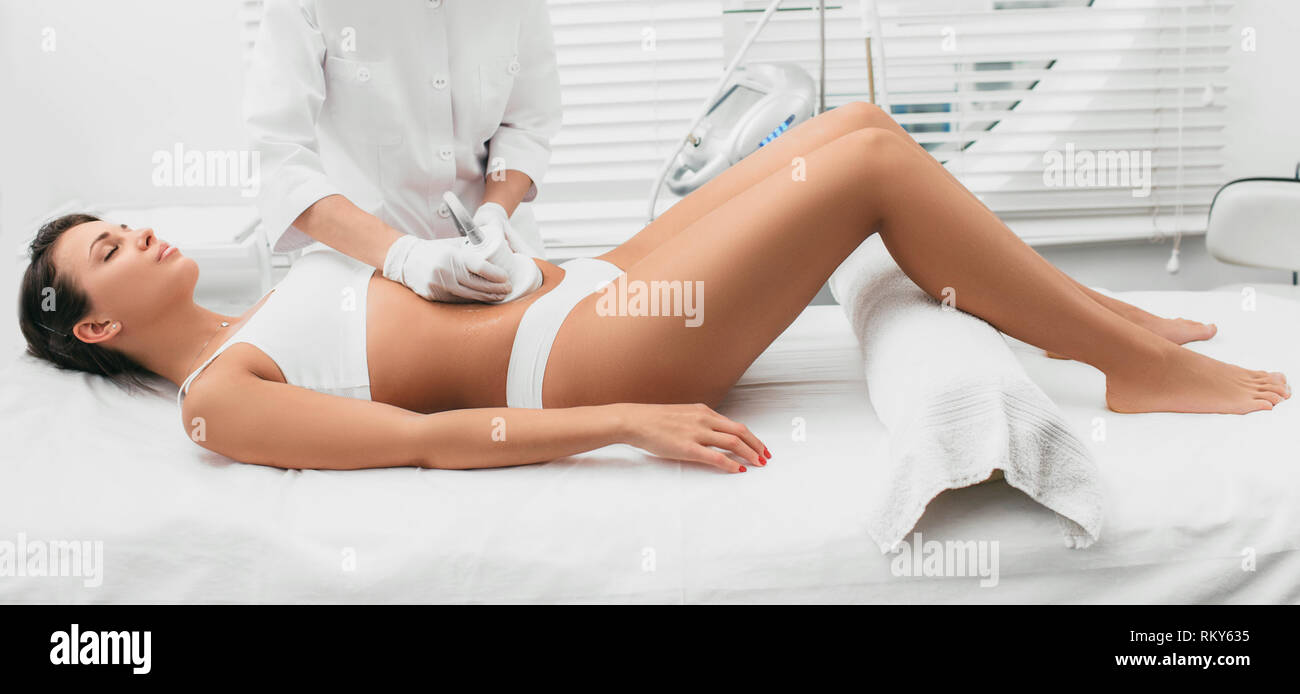 Hermosa mujer que la cavitación , tratamiento celulitis, sobre su abdomen en Beauty Clinic Foto de stock