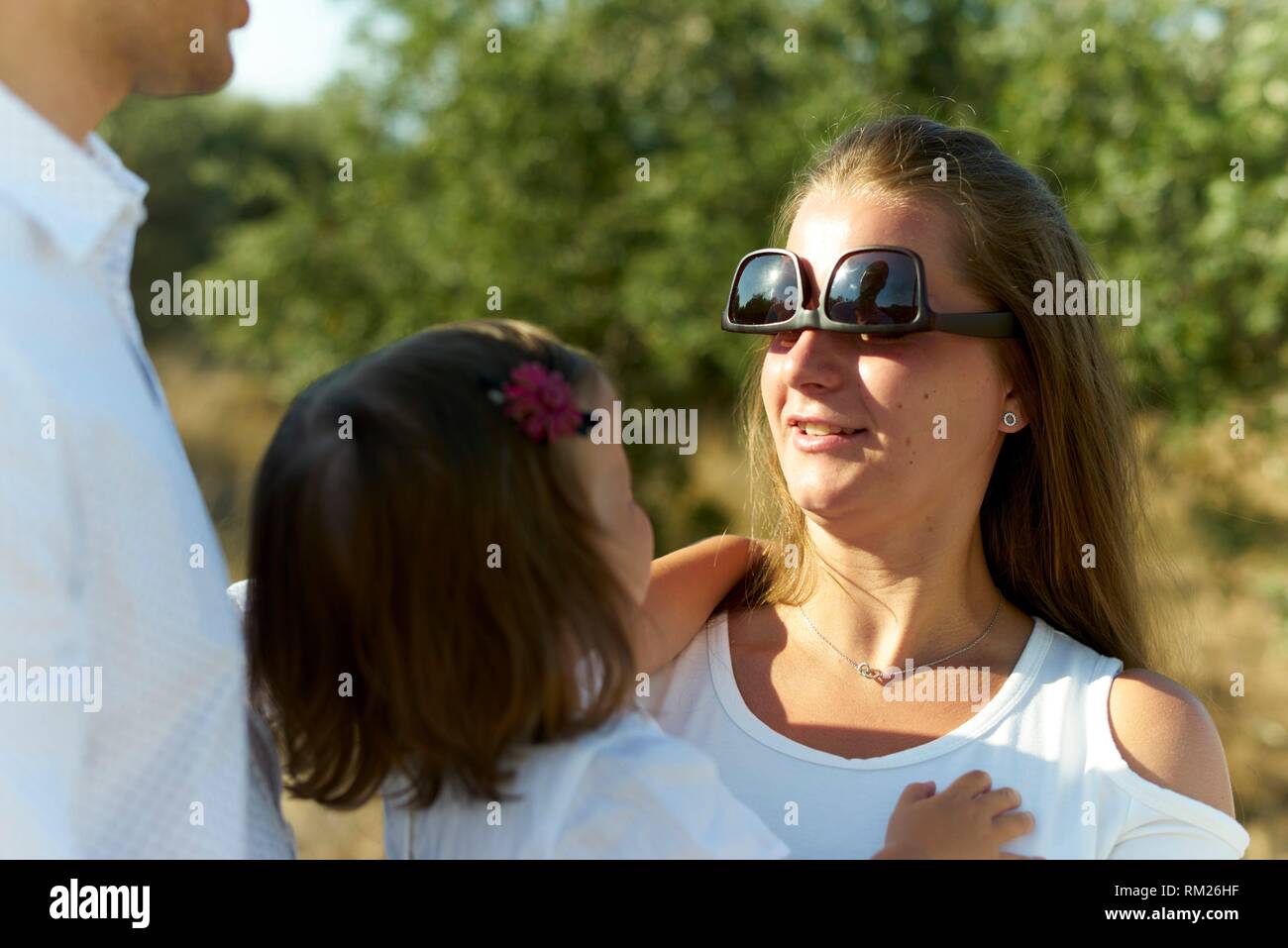 Madre con gafas de sol al revés, sosteniendo infante hija en brazos.  Gracioso, humorístico, maternidad, diferentes Fotografía de stock - Alamy