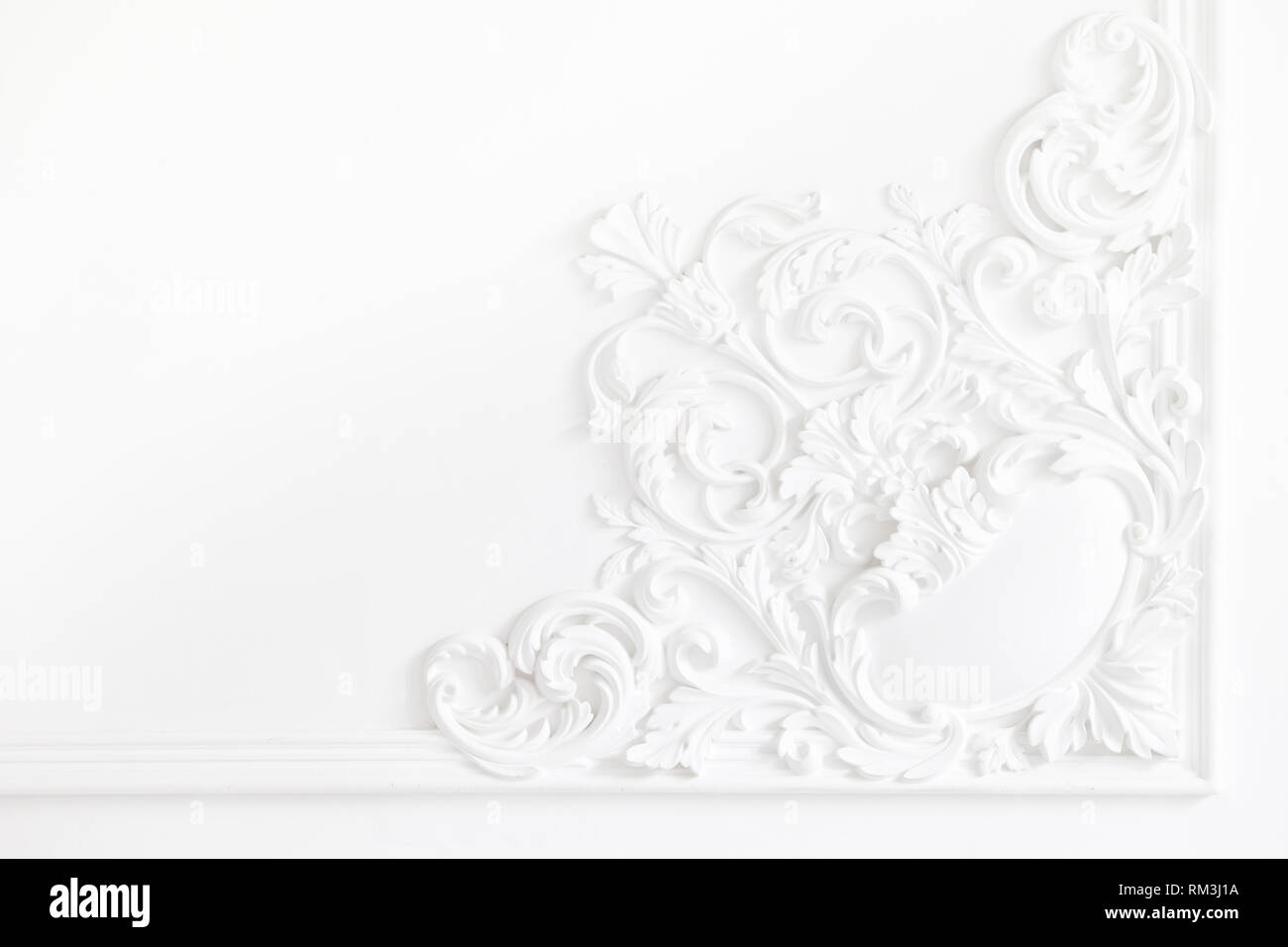 Bonita blanco molduras de yeso decorativas en studio. La pared blanca está  exquisitamente decorada con elementos de estuco de yeso Fotografía de stock  - Alamy