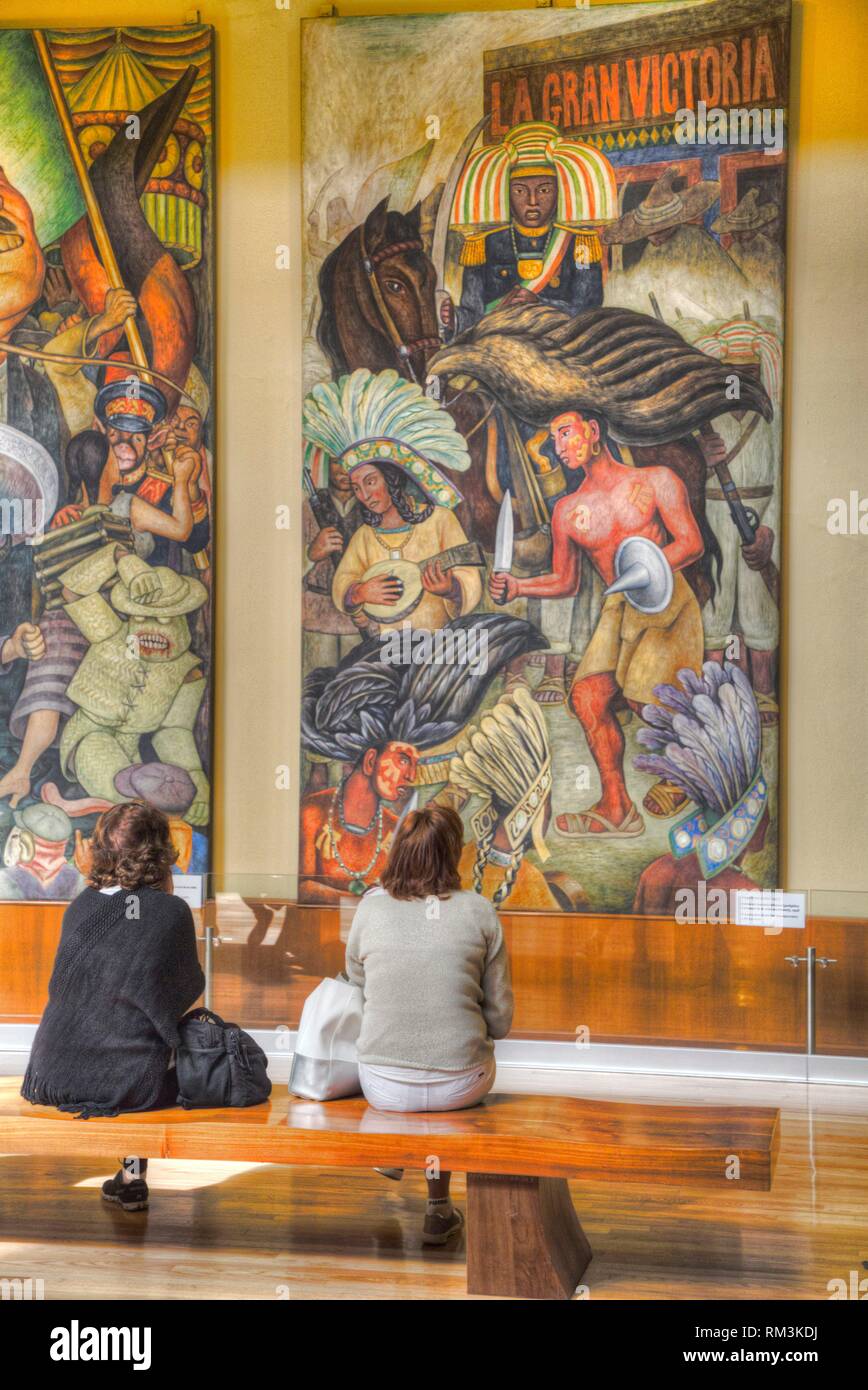 Las mujeres admirando las pinturas murales de Diego Rivera, el Palacio de Bellas Artes, Ciudad de México, México Foto de stock