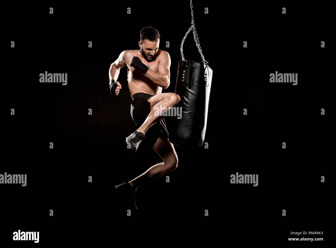 Capacitación para el gran día. Atlético muscular tatuado hombre en ropa  deportiva formación sobre patas de boxeo con su pareja en el gimnasio de  boxeo negro Fotografía de stock - Alamy