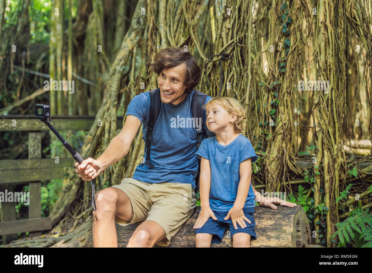 Padre e hijo los viajeros descubrir Ubud bosque en el bosque de los monos, Bali, Indonesia. Viajar con niños concepto. Videoblog, Selfie. Foto de stock