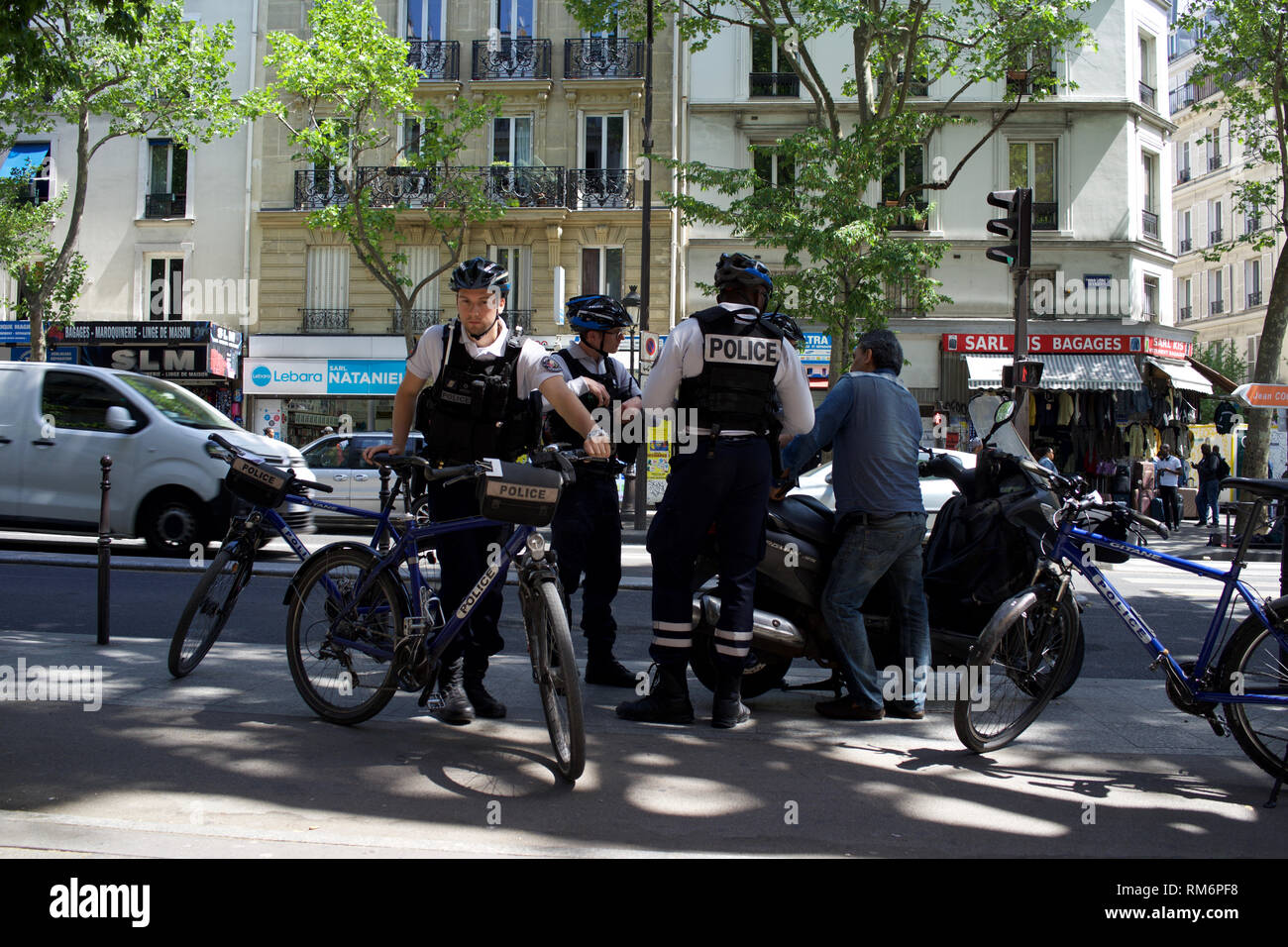 Oficiales de policía franceses montados interrogar al hombre con motocicleta, boulevard Barbès, 75018, París, Francia Foto de stock