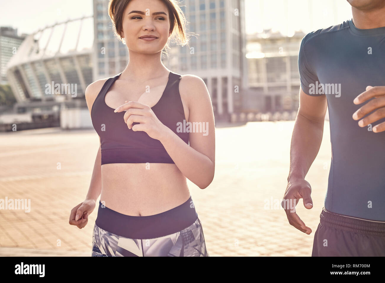 Hermosa pareja multirracial de atletas jóvenes correr juntos en un soleado día cálido. Aficiones comunes. Pareja saludable. Concepto de motivación deportiva. Concepto de fitness. La belleza de las mujeres. Vida sana. Ejercitarse juntos Foto de stock