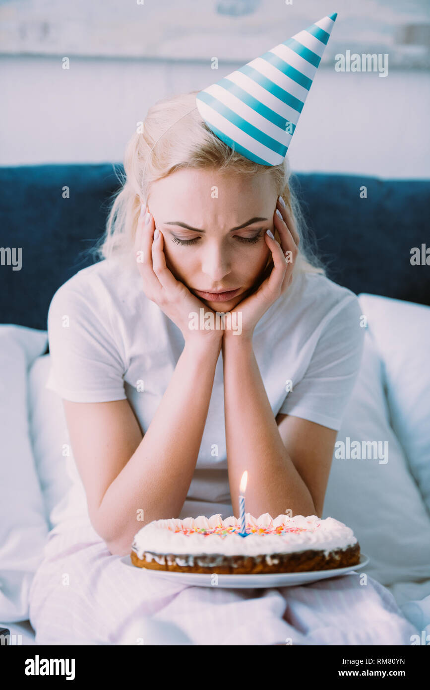 Mujer mirando deprimido durante la celebración de la torta de cumpleaños en  cama sola Fotografía de stock - Alamy