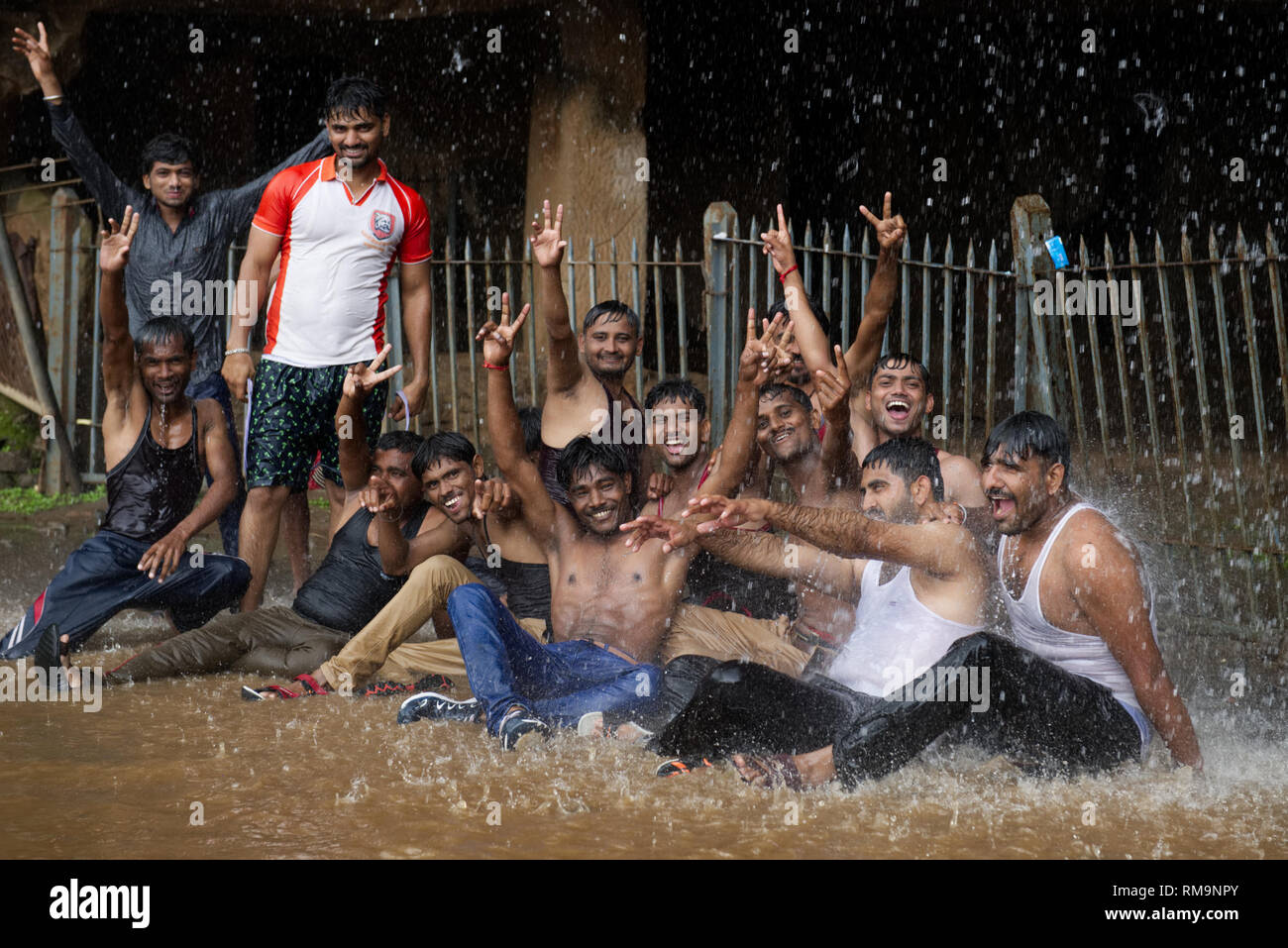 Un alegre grupo que goza de las lluvias monzónicas. Celebrando el clima de Mumbai. Foto de stock