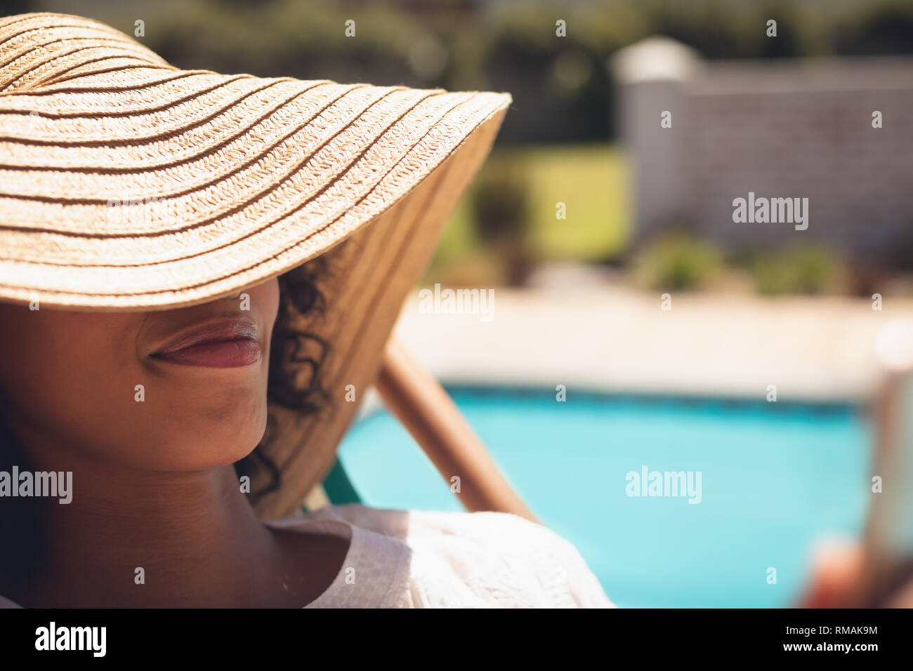 Afroamericana con hat relajarse en las hamacas en el jardín de su casa Foto de stock
