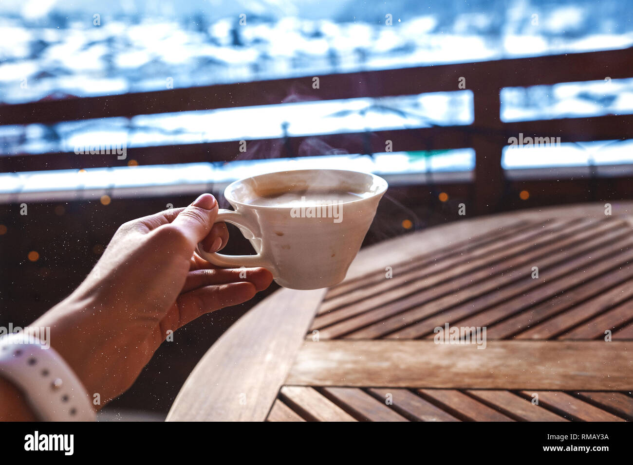 Por la mañana. Montañas de aire fresco. Disfrute aromático, sabroso, cálido y relajante taza de café expreso. Vista sobre las montañas nevadas. Oferta Señoras mano holidng la copa Foto de stock