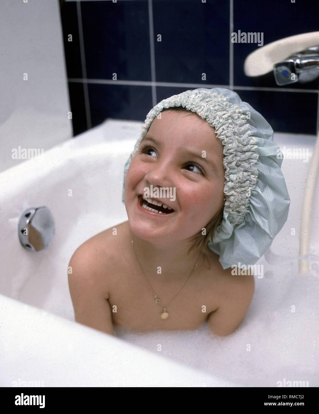 Niña con gorro de ducha en la bañera Fotografía de stock - Alamy