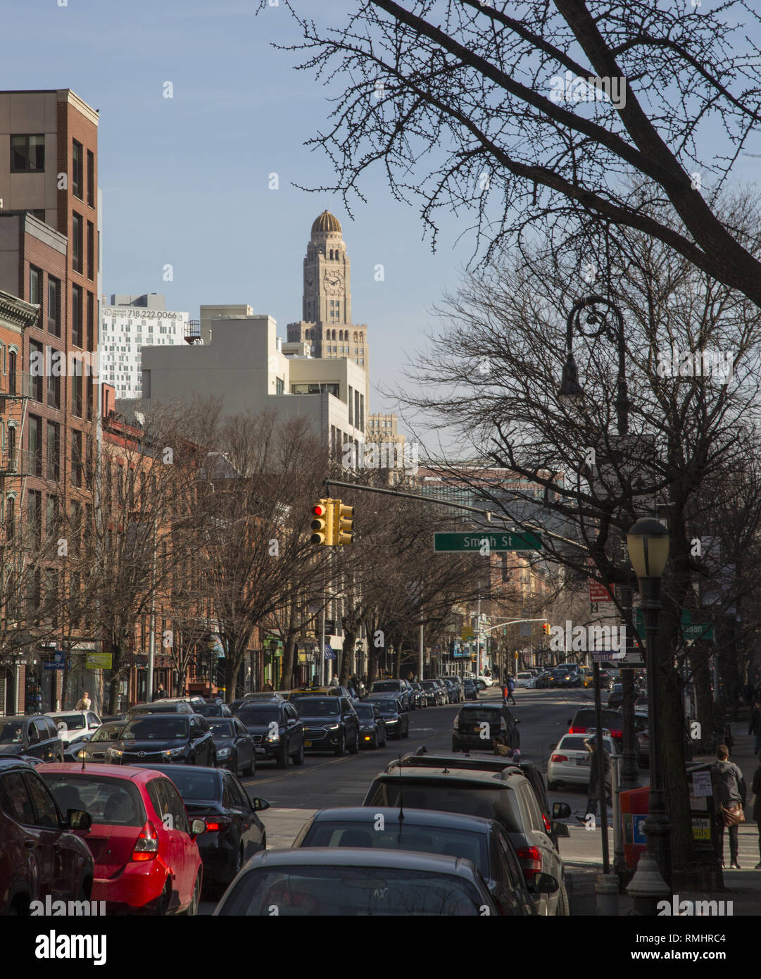 Mirando hacia el este hacia abajo en la calle Schermerhorn Boerum Hill barrio de Brooklyn, NY con la icónica Williamsburg Savings Bank torre del reloj asomándose en el fondo. Foto de stock