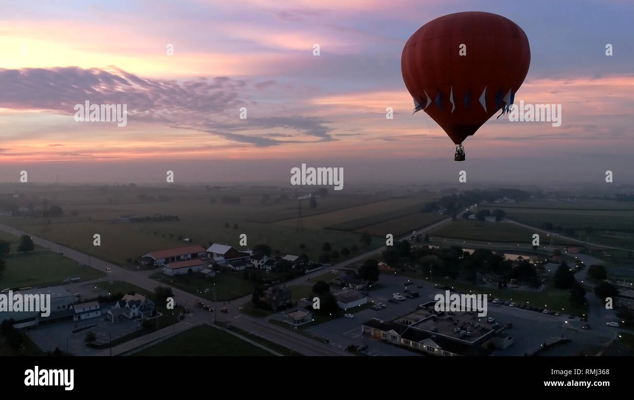 Vista aérea del amanecer con globos aerostáticos despegando con bujías visto por un zumbido Foto de stock