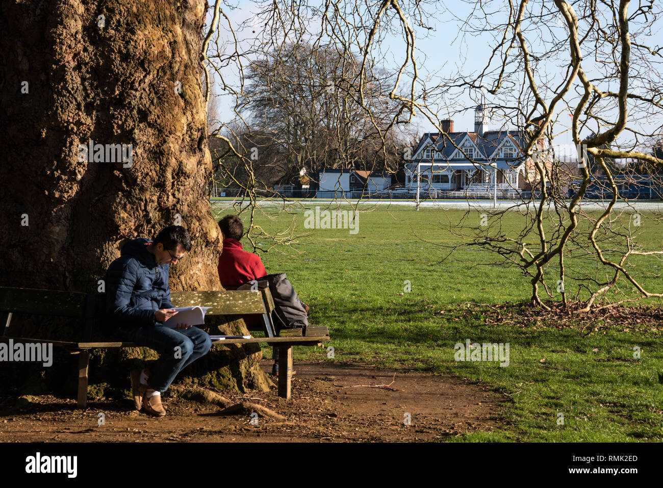 Los estudiantes en un banco, de la Universidad de Oxford Parques en invierno Foto de stock