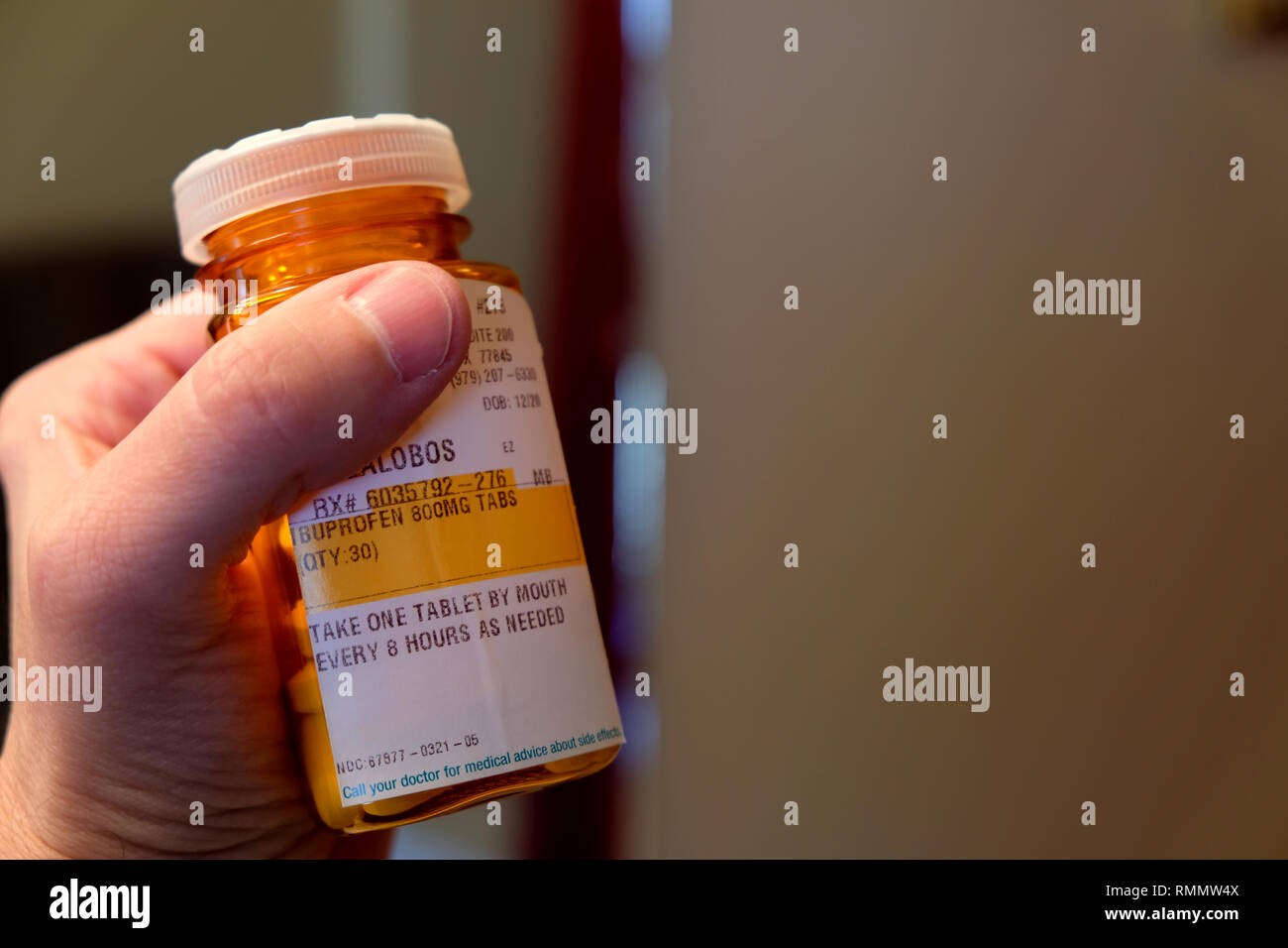 Mano de hombre sosteniendo una botella de prescripción fuerza ibuprofeno;  receta con instrucciones; 800 miligramos Fotografía de stock - Alamy