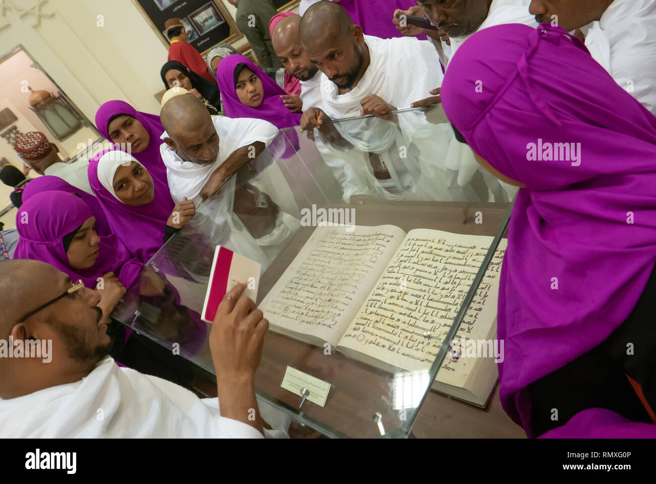 MEDINA, Arabia Saudita-circa 2016 : un grupo de peregrinos musulmanes de la India escuche su líder explica la primera versión del Corán en un museo. Foto de stock